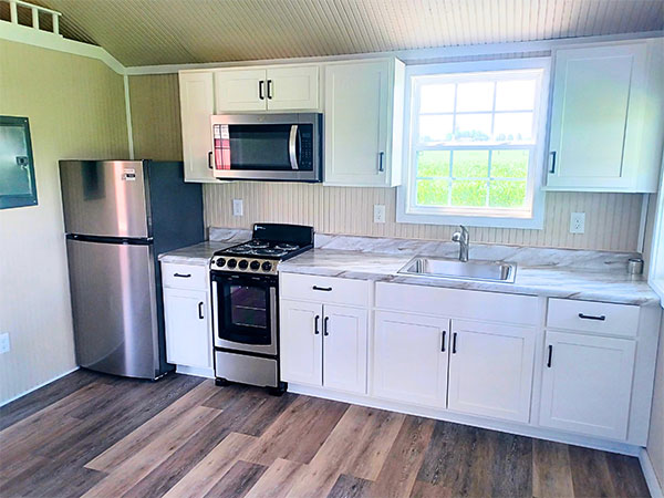 Finished Portable Buildings with kitchen. White cabinets & silver appliances