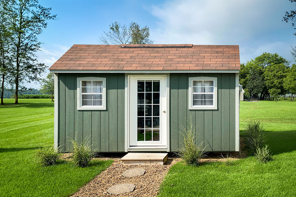 Green home office shed with white trim.